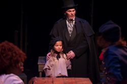 Jean Valjean (Daniel Felton) pays the Thenardiers to take young Cosette (Ella Boodin) to raise her in a warm and loving home